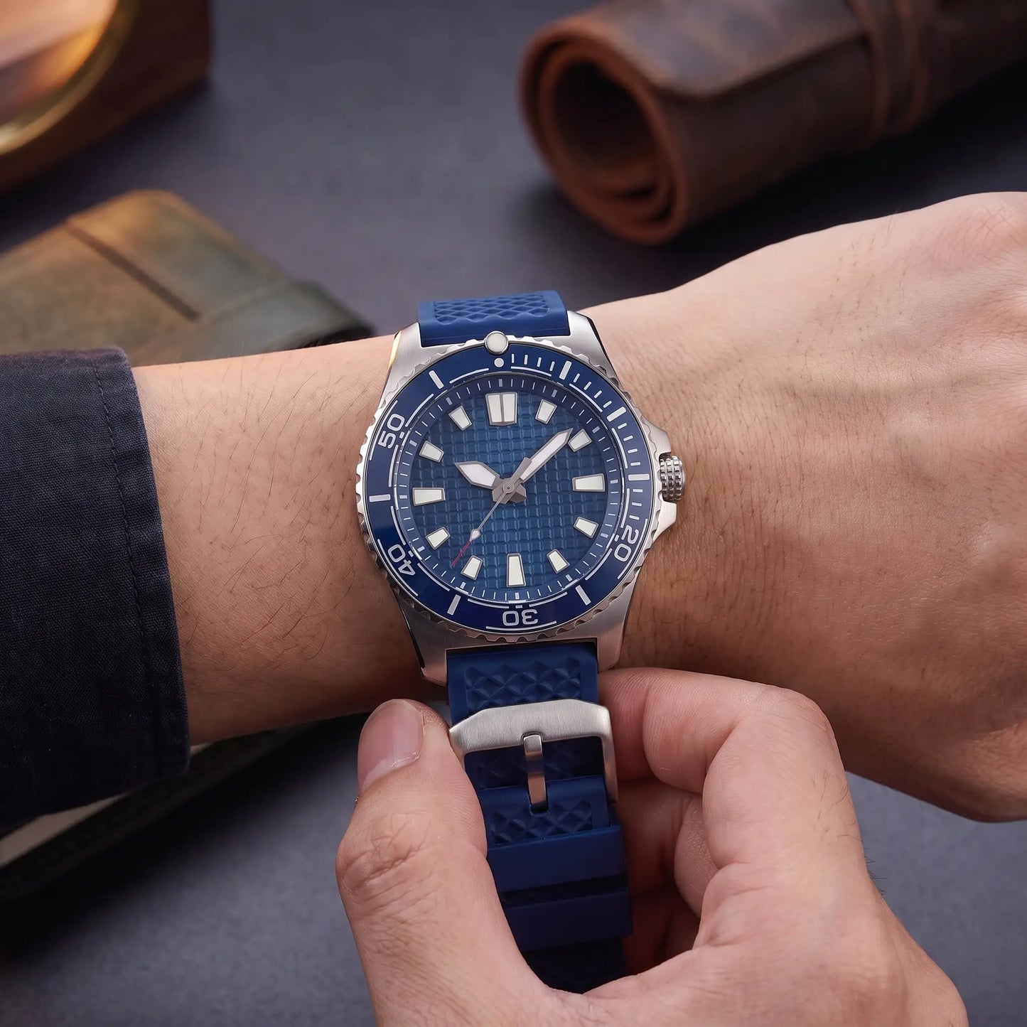 CERAMIC BEZEL WATCH worn on the wrist - fastening the blue rubber strap through the steel buckle