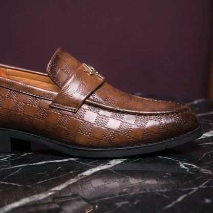 Close-up of the loafer strap, gold ornament and embossed check leather
