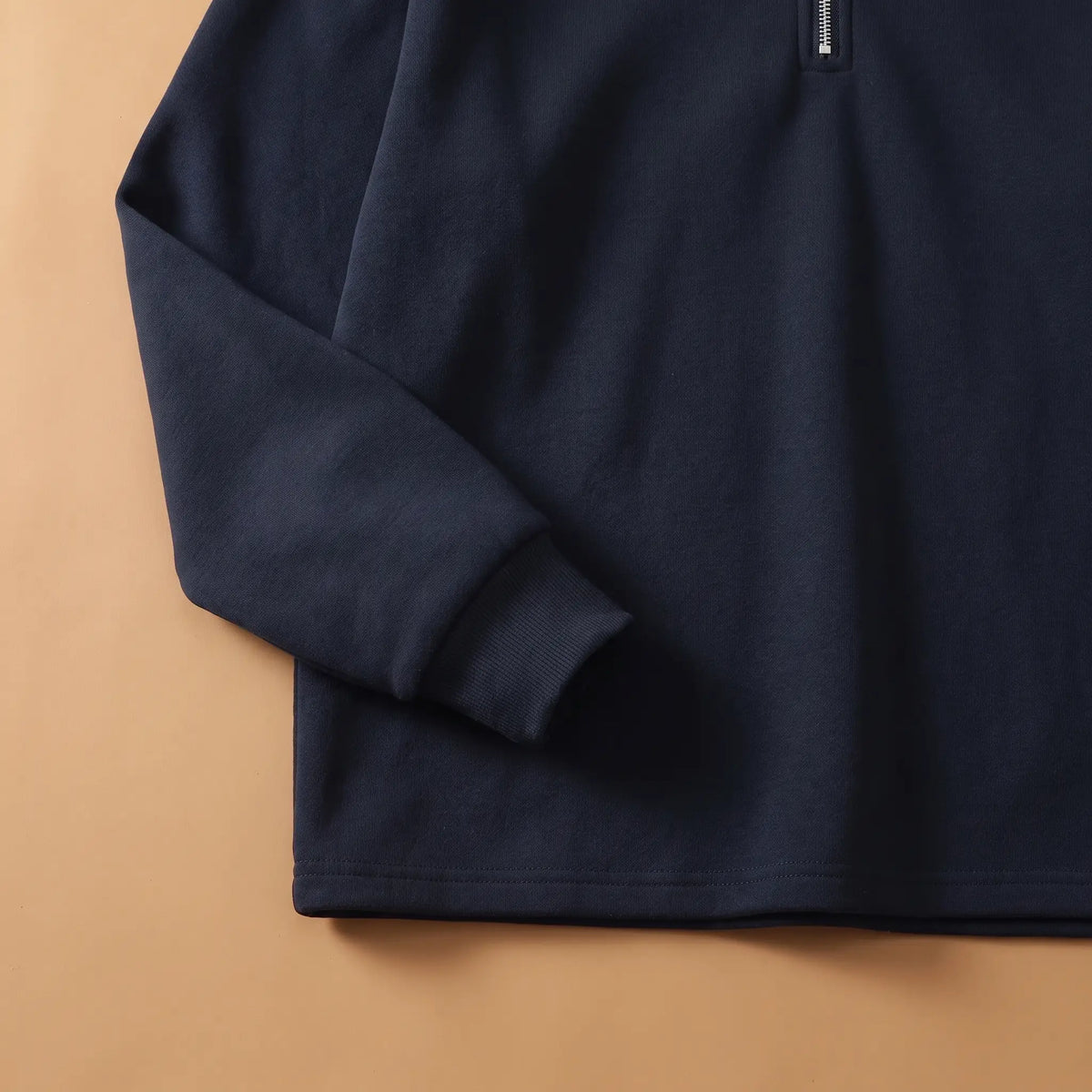 Close-up of men's navy blue half-zip sweatshirt ribbed cuff and hem