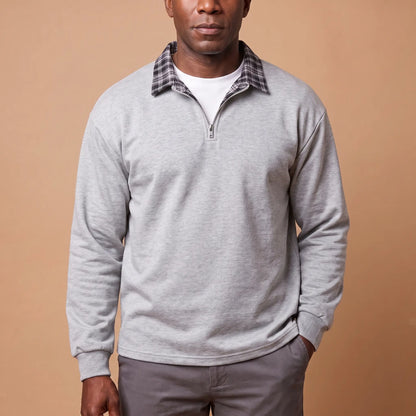 Man wearing light grey half-zip sweatshirt with check shirt collar and grey chinos