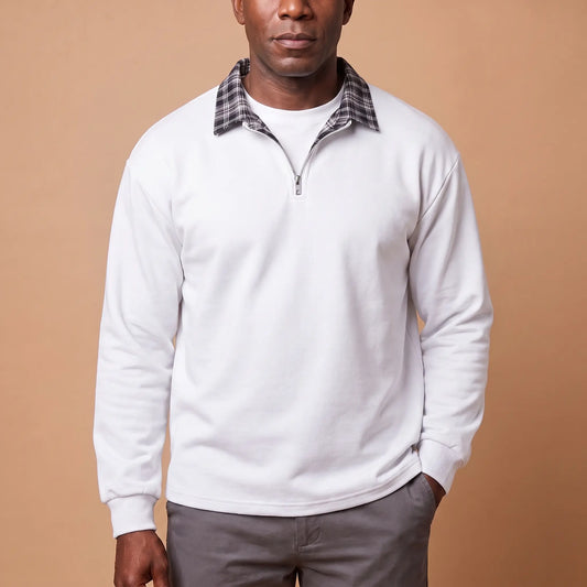 Man wearing white half-zip sweatshirt with check shirt collar and grey chinos