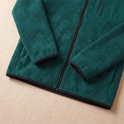 Close-up of the bound cuff and hem on the green chevron knit jacket
