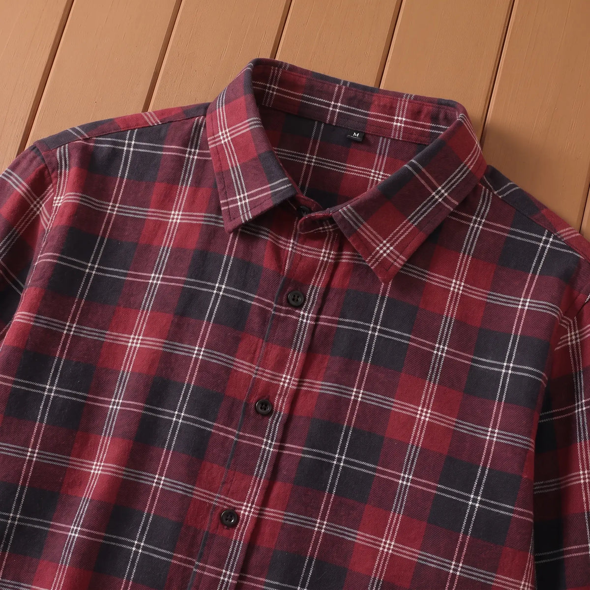 Close-up of red plaid shirt point collar and button front