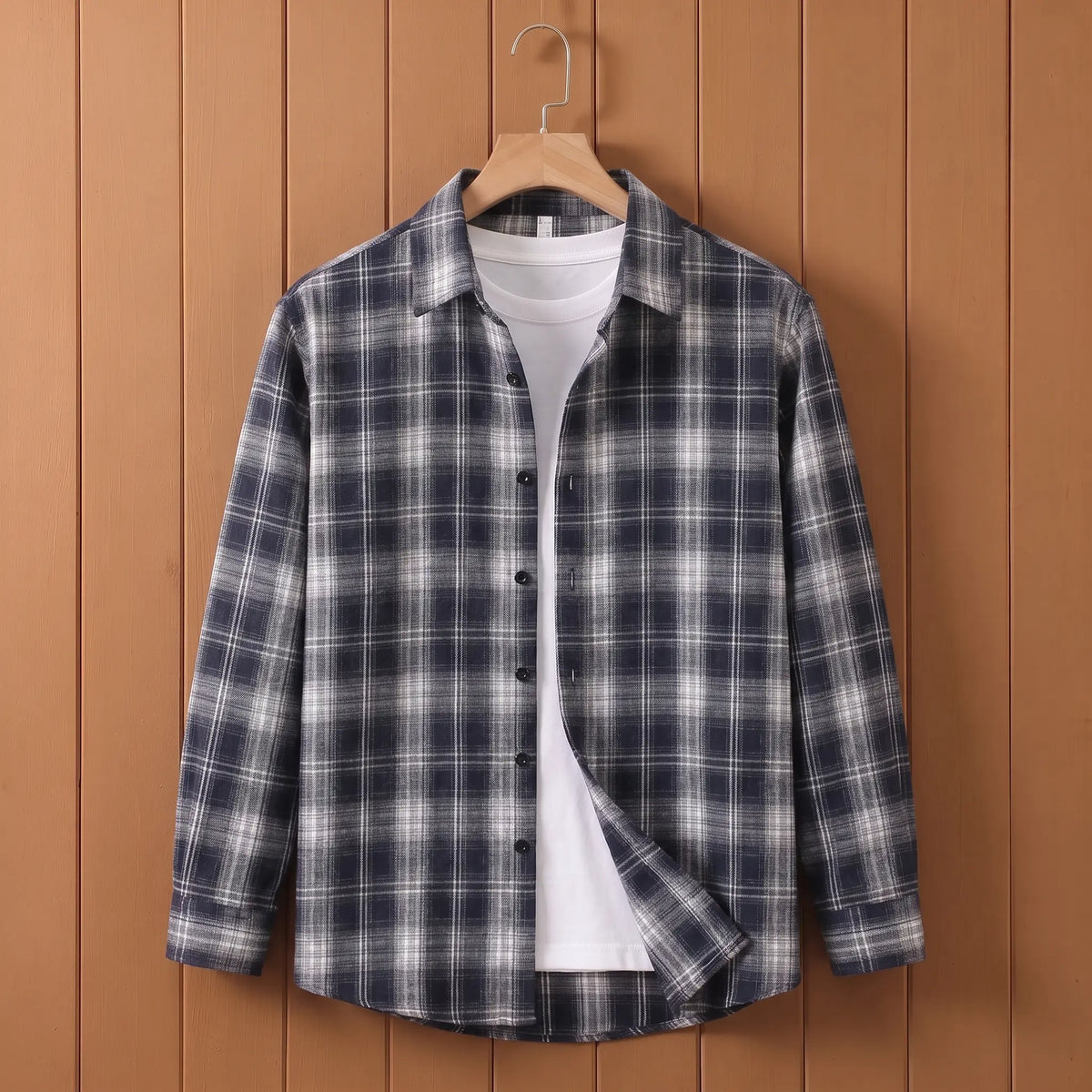 Men's navy blue plaid long-sleeve button shirt open over a white tee on a wooden hanger