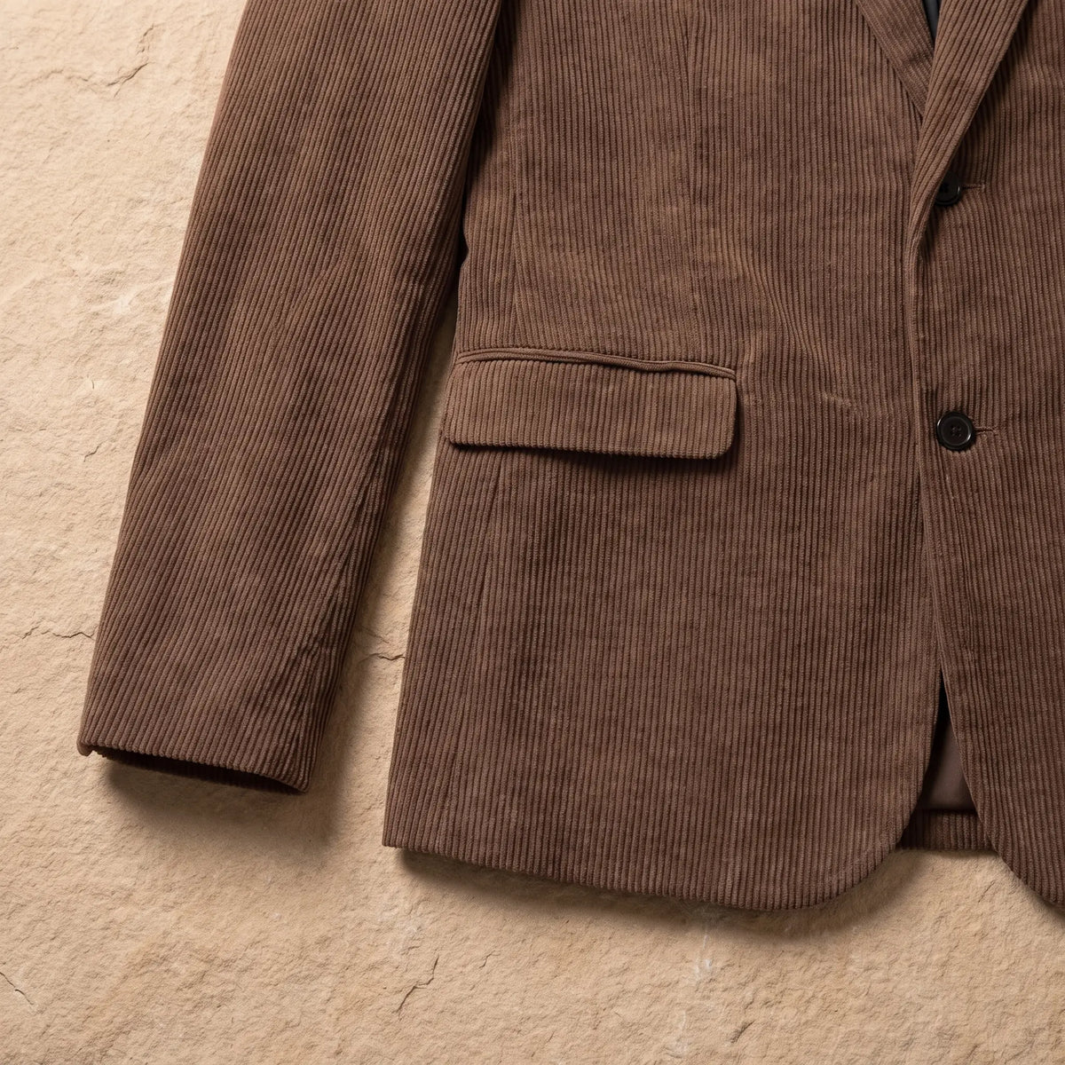 Close-up of brown corduroy blazer flap pocket, hem and cuff