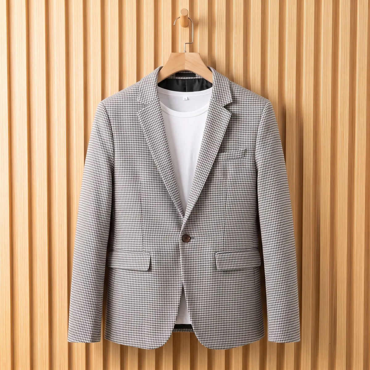 Men's light grey houndstooth single-button blazer over a white tee on a wooden hanger