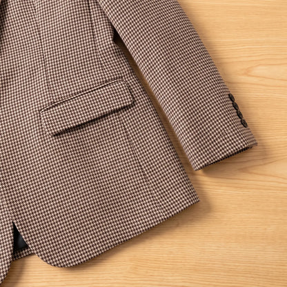 Close-up of brown houndstooth blazer flap pocket and button cuff
