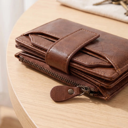 Close-up of the strap tab and zip coin pocket on the brown wallet
