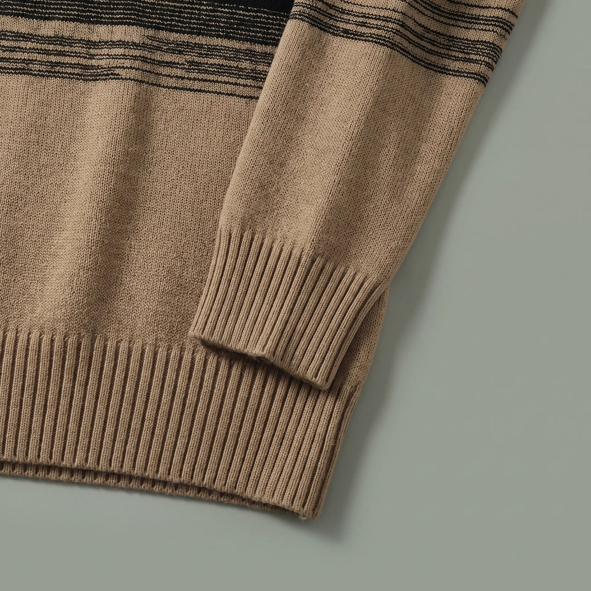 Ribbed cuff and ribbed hem of the khaki ombre knit sweater laid flat