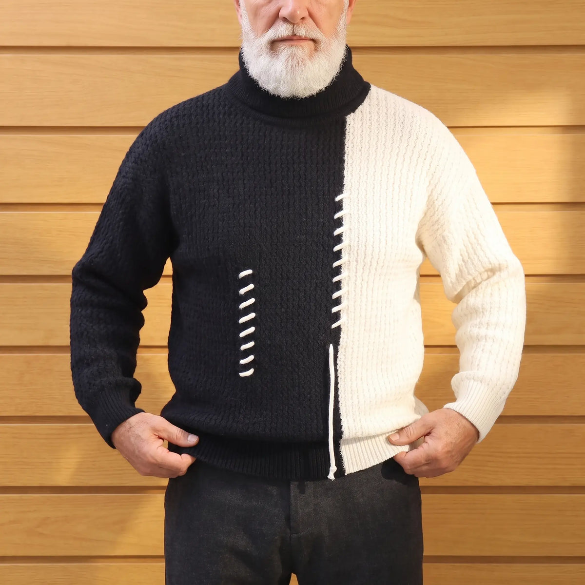 Man straightening the hem of a black and cream colour block turtleneck