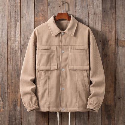 Men's beige corduroy work jacket with snap front and flap chest pockets on a wooden hanger