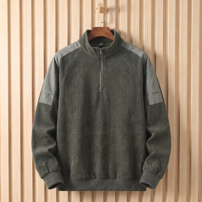 Men's army green corduroy quarter-zip sweatshirt with grey shoulder panels on a wooden hanger