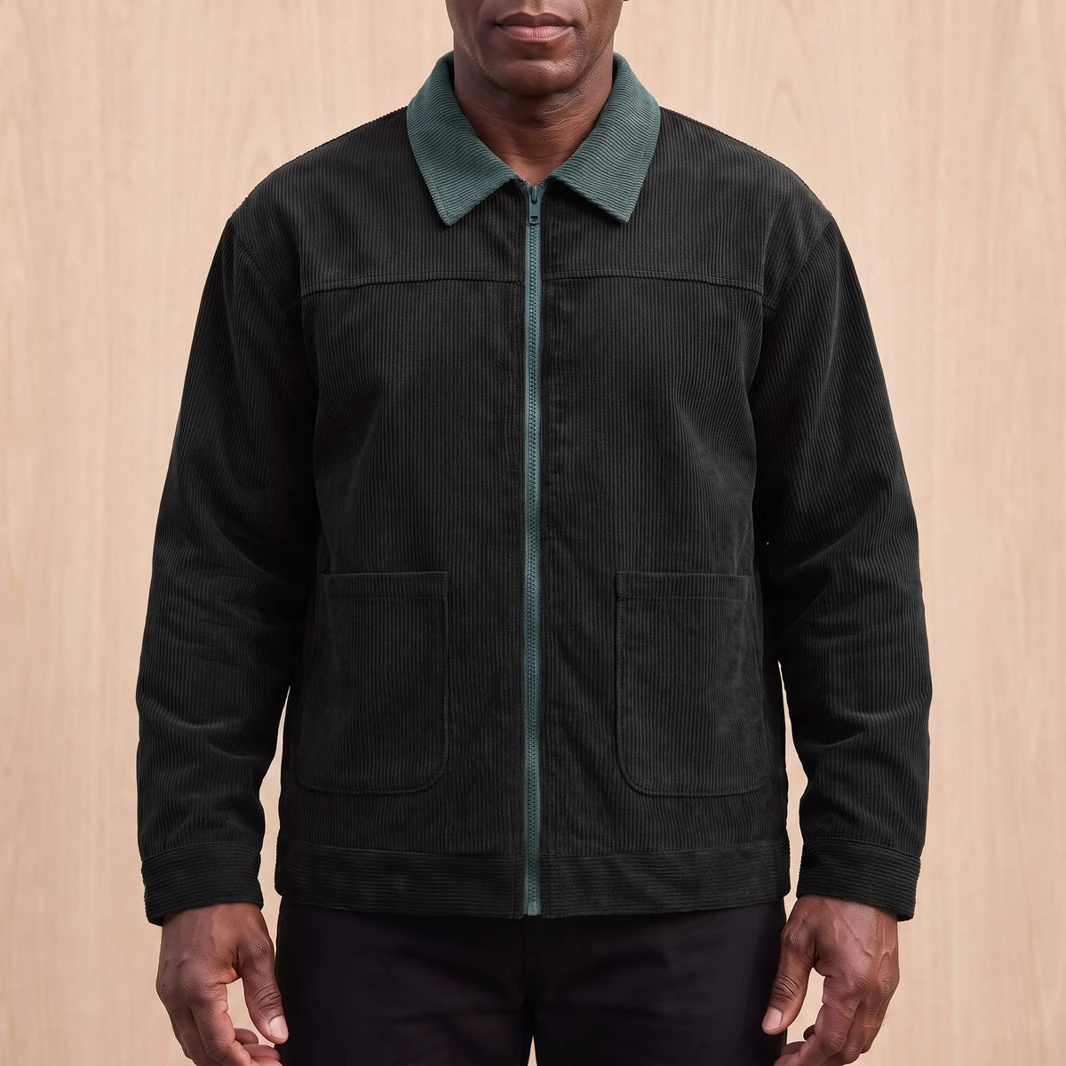 Men's black corduroy zip jacket with a green corduroy collar and two patch pockets, worn zipped