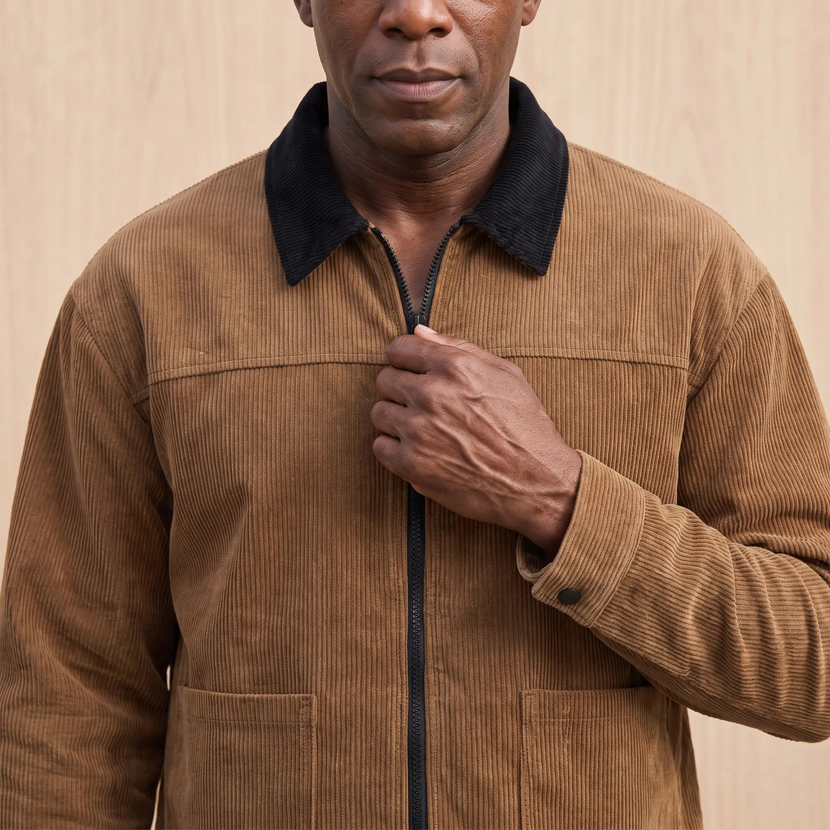 Man zipping up the brown cord collar jacket