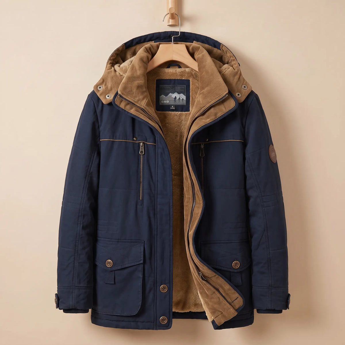 Men's navy blue fleece-lined hooded parka with corduroy collar, zip chest pocket and snap flap pockets on a wooden hanger