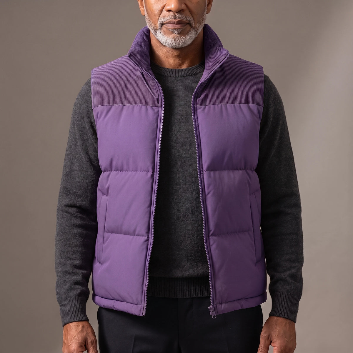 Men's purple quilted puffer vest with ribbed cord collar and shoulder yoke, worn open over a charcoal knit