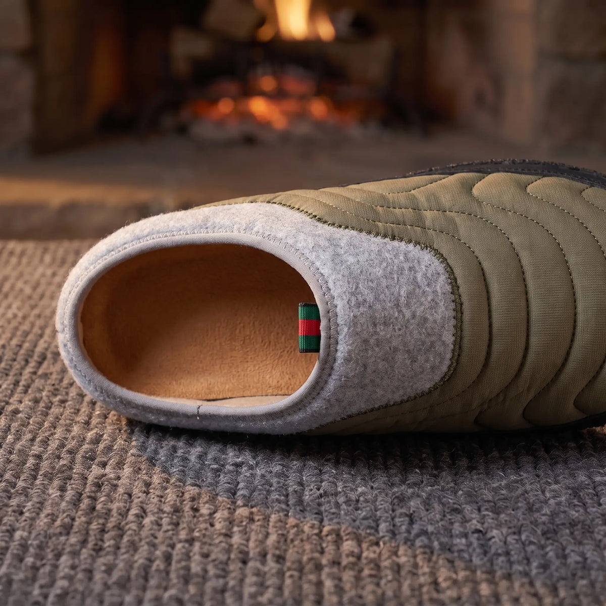 Close-up of green quilted slipper showing grey felt collar and soft lining
