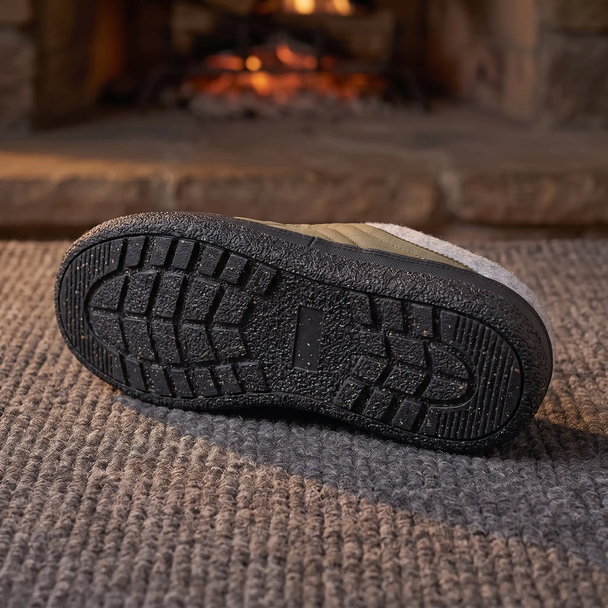 Underside of green quilted slipper showing the rubber outsole