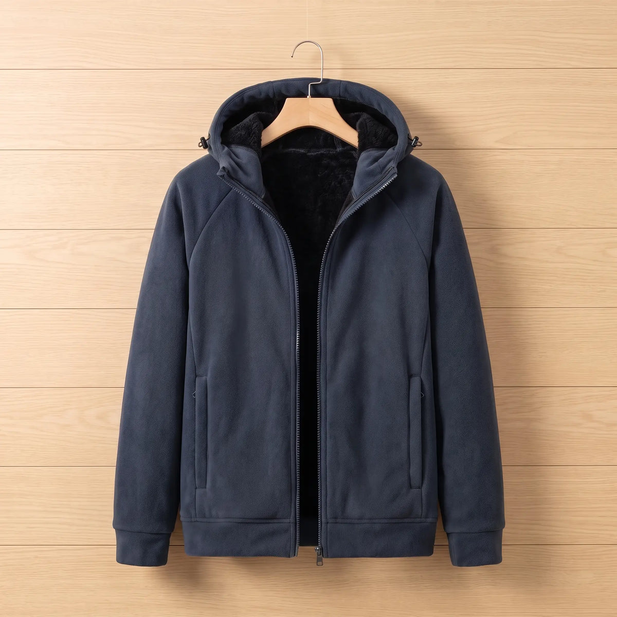 Men's navy blue full-zip fleece jacket with black plush-lined hood, zip pockets and ribbed cuffs on a wooden hanger