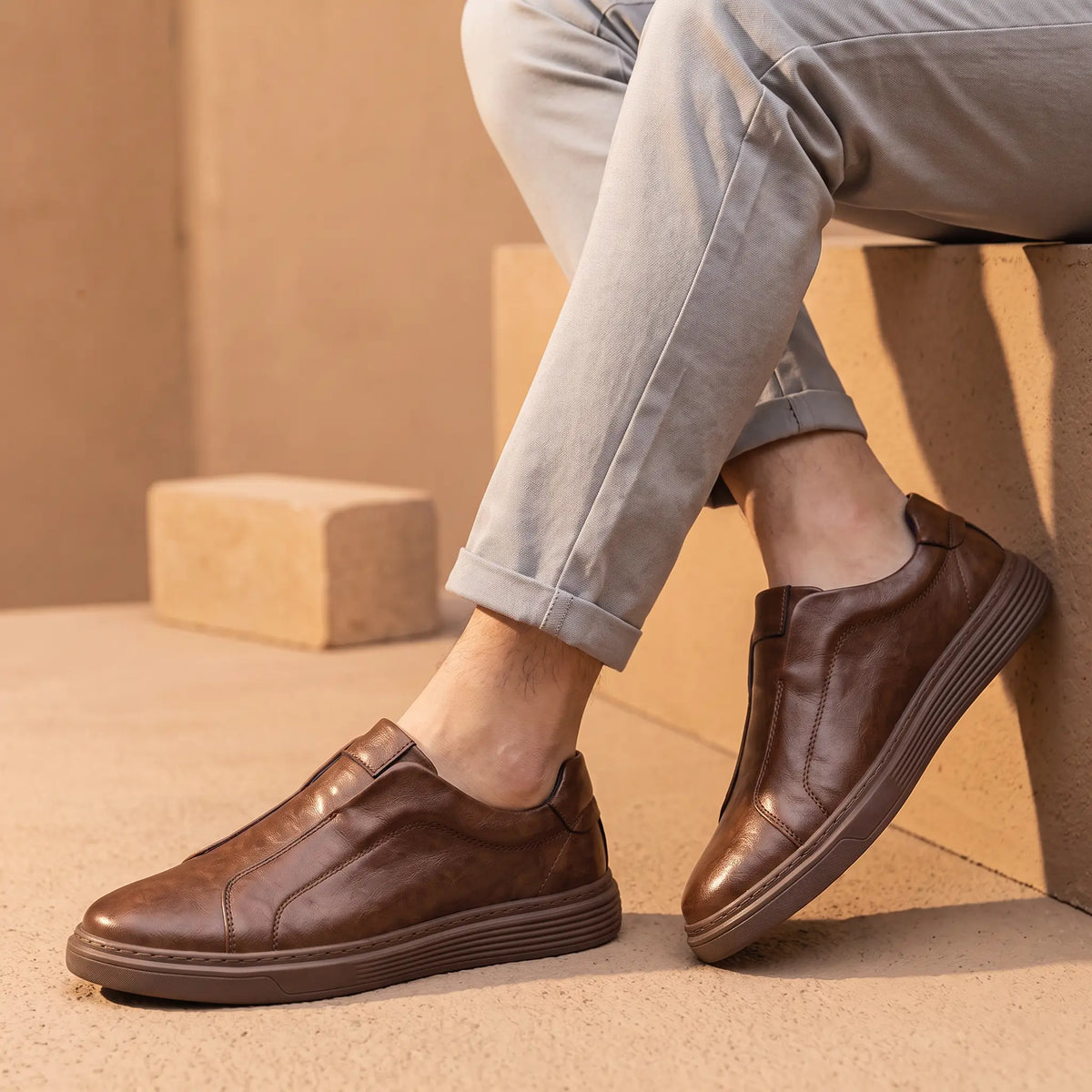 Creased Leather Sneakers in Brown worn as a pair with grey chinos