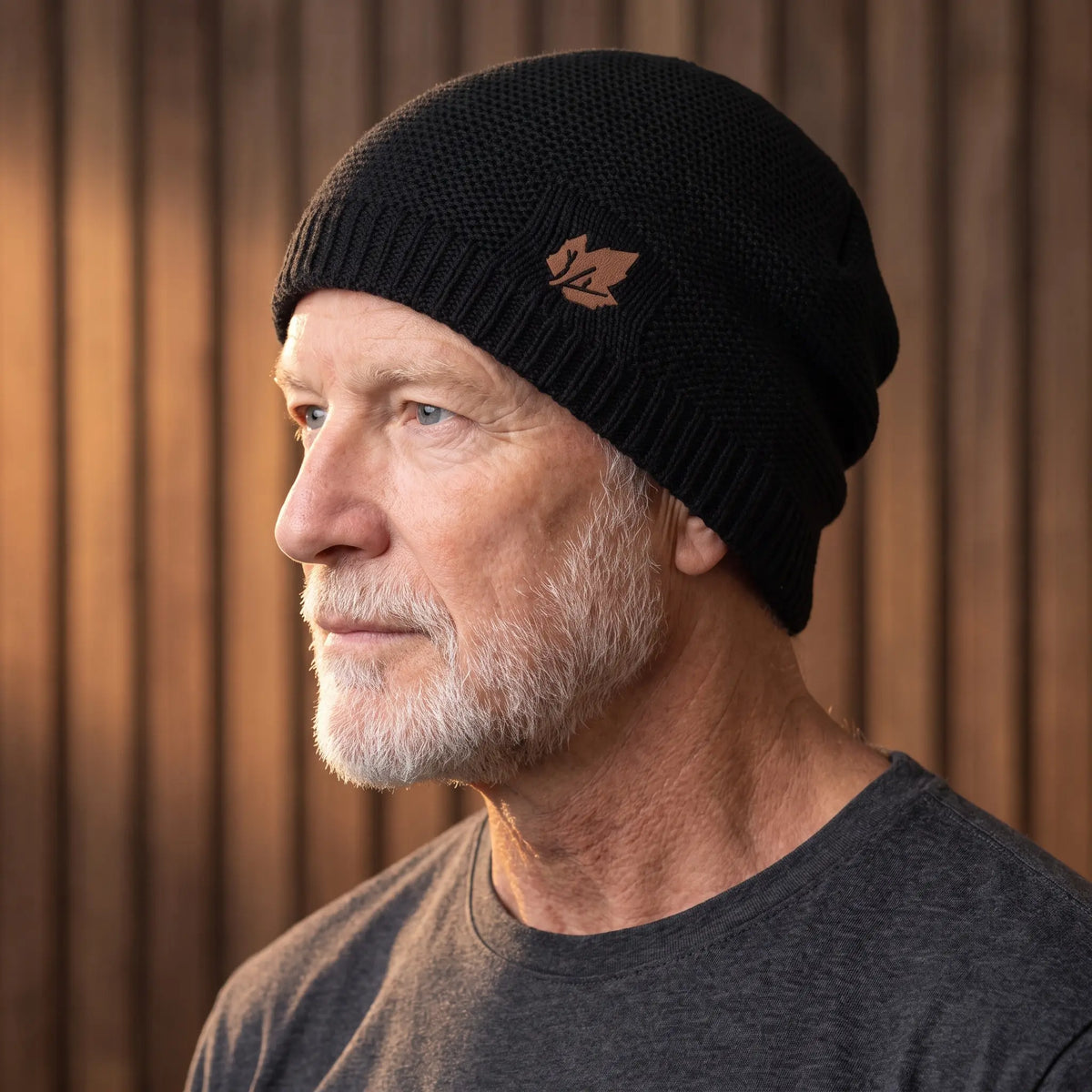 Black cuffed knit beanie for men worn with a turn-up cuff over the ears