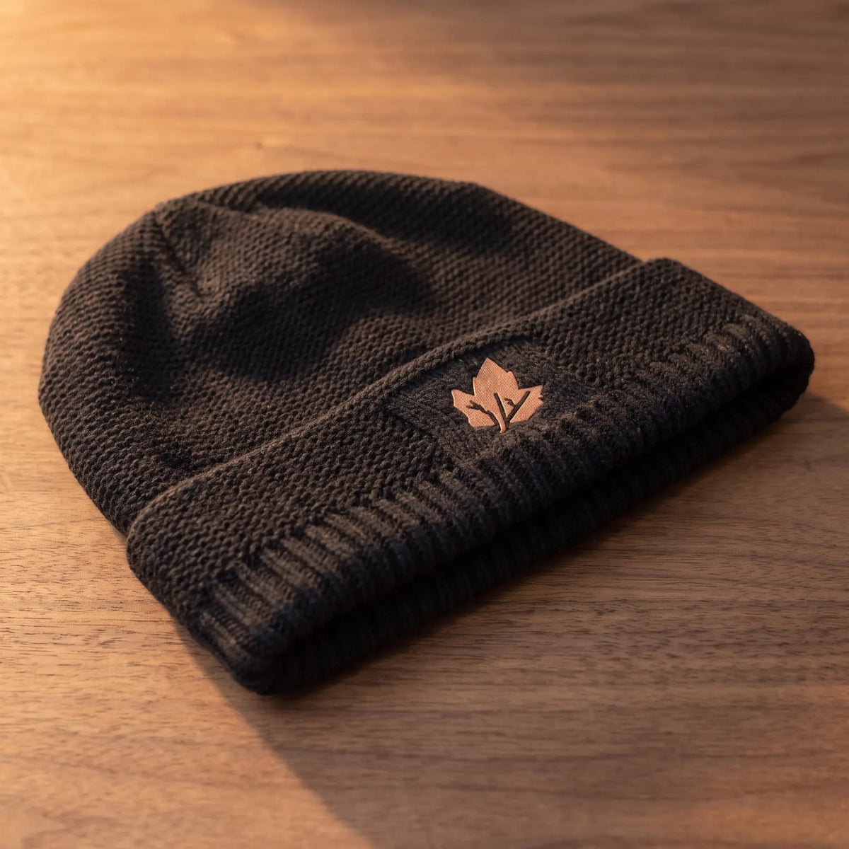 Side view of the black knit beanie showing the slouch at the back