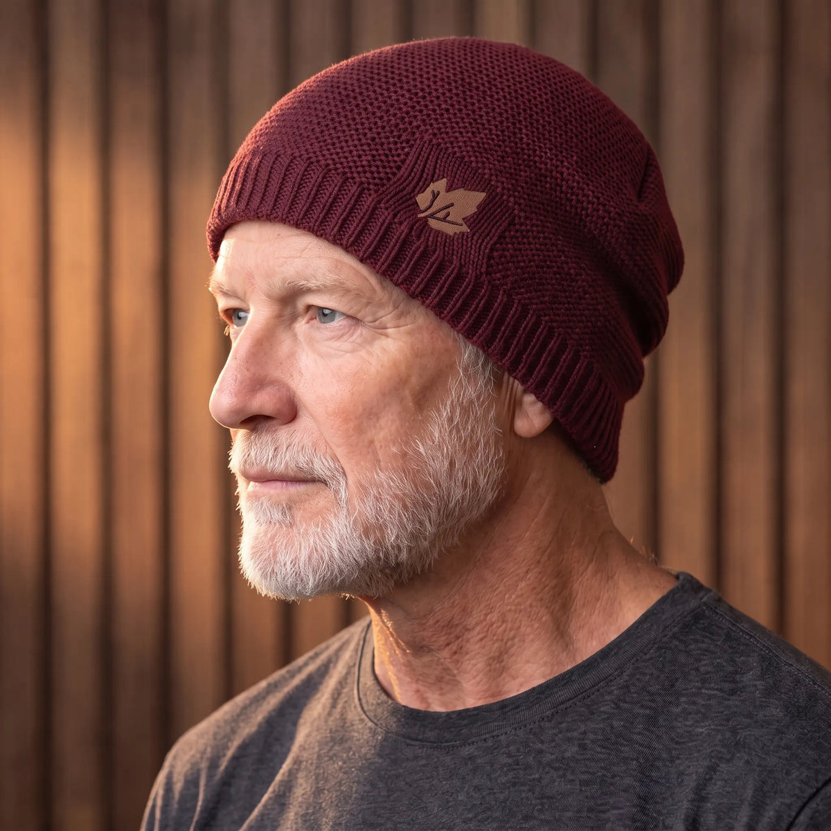 Red cuffed knit beanie for men worn with a turn-up cuff over the ears