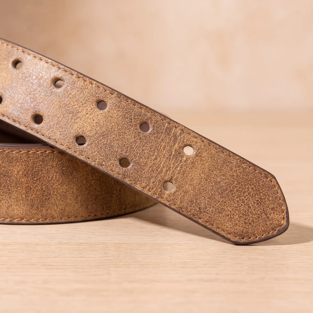 Close up of the DOUBLE PIN BELT strap showing two rows of punched holes and the tapered tip