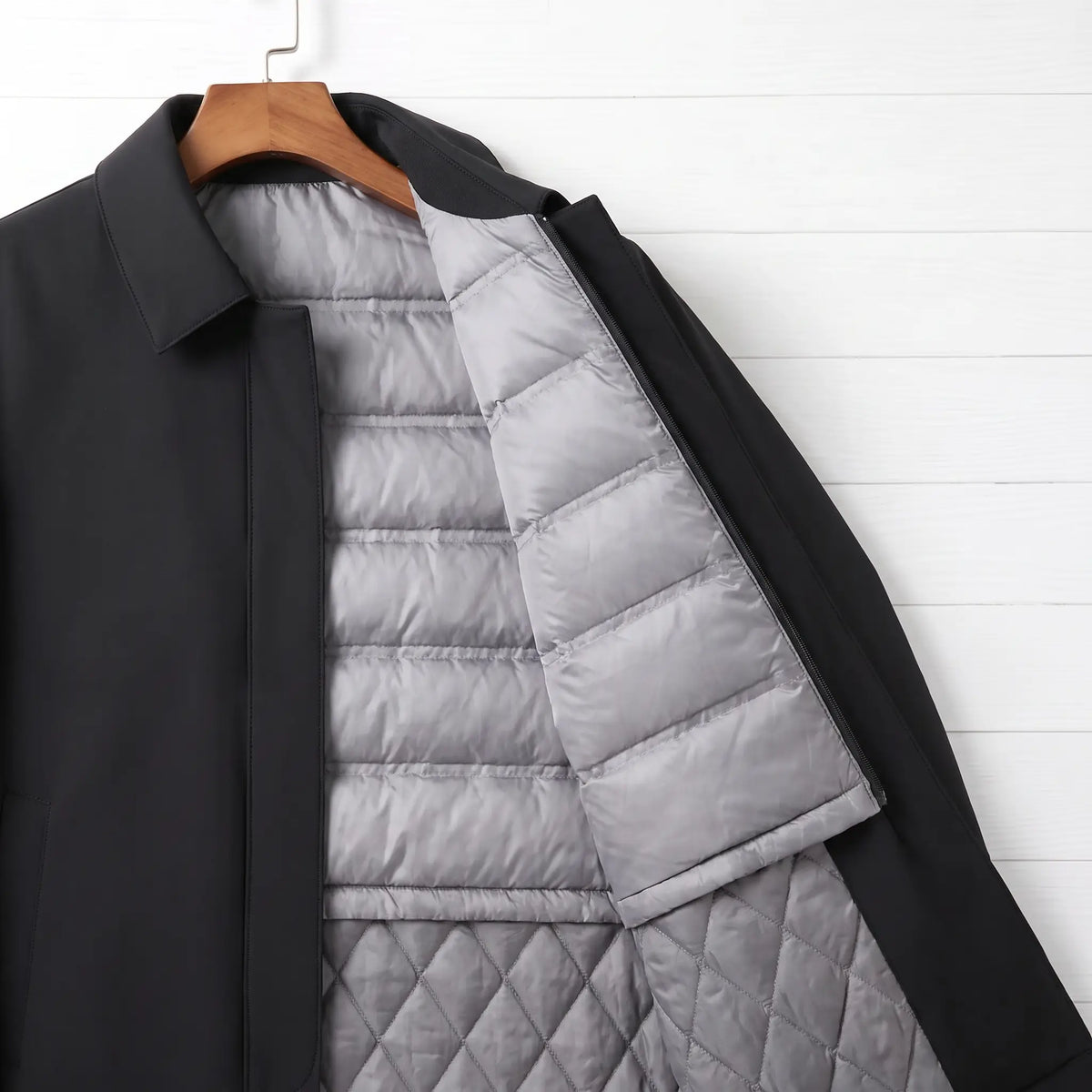 Zip-out quilted down liner inside a black down lined coat for men