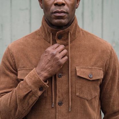 Man fastening the collar button on the brown drawcord collar jacket