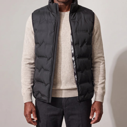 Men's black duck down vest with wave quilting, worn open over an oatmeal sweater