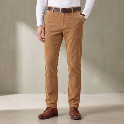 Tan fine wale corduroy trousers worn with a brown leather belt and derby shoes