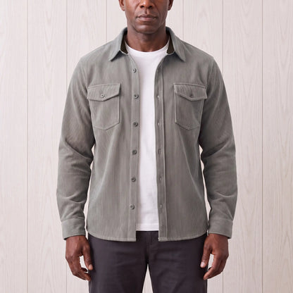 Man wearing the Fine Cord Overshirt in grey, a corduroy shirt jacket open over a white tee