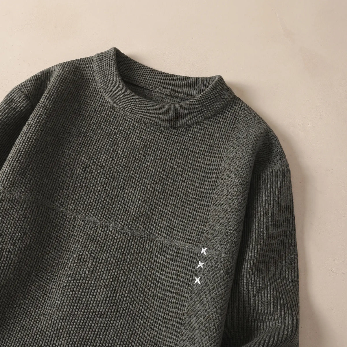 Close-up of the green fine rib sweater collar and chest seam