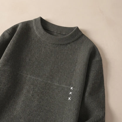 Close-up of the green fine rib sweater collar and chest seam