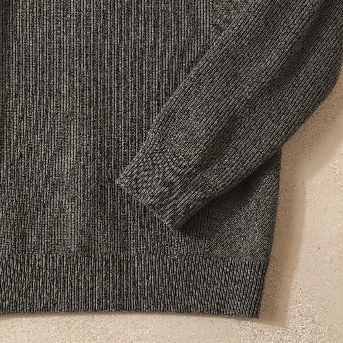 Close-up of the green fine rib sweater ribbed cuff and hem