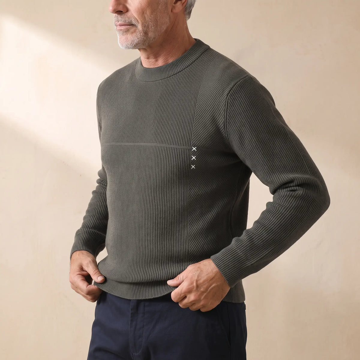 Man wearing the green fine rib sweater, pulling down the hem