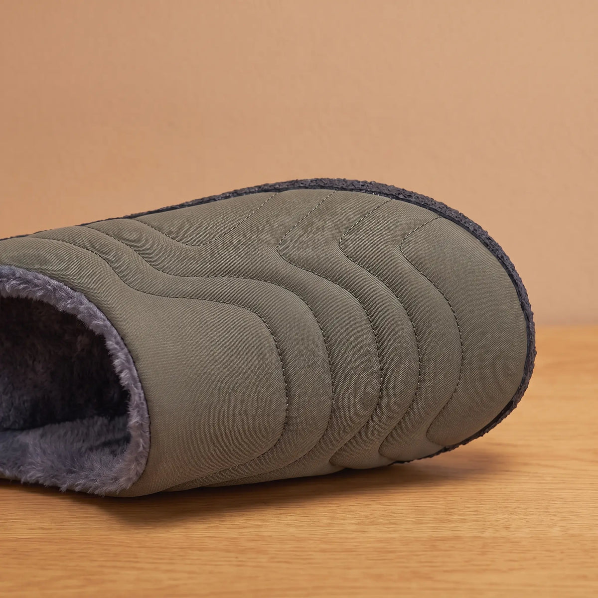 Close-up of green quilted slipper toe showing wave stitching and plush lining