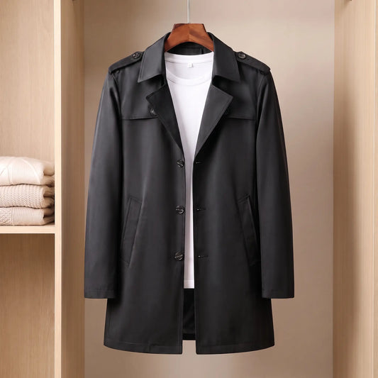 Flap Pocket Coat in black, a slim mid-length single-breasted trench coat with epaulettes and hip flap pockets on a wooden hanger