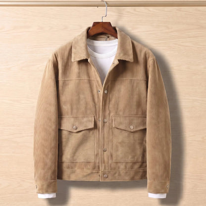 Beige corduroy flap pocket jacket on a wooden hanger against a light oak wall