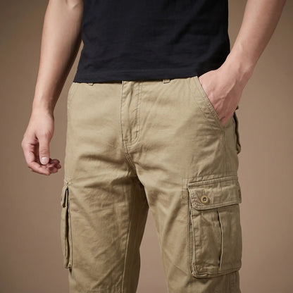 Man wearing the FLAP POCKET TROUSERS in khaki with a hand in the front pocket