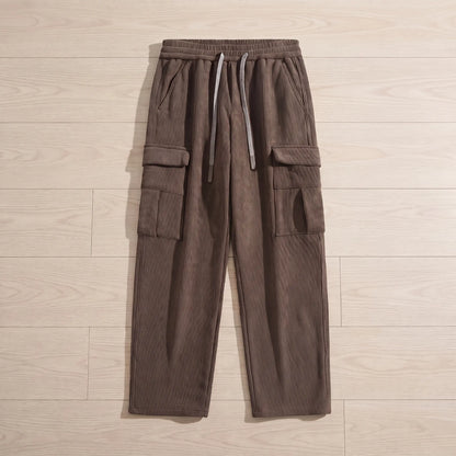 Fleece cord cargos in brown corduroy laid flat on pale wooden floorboards