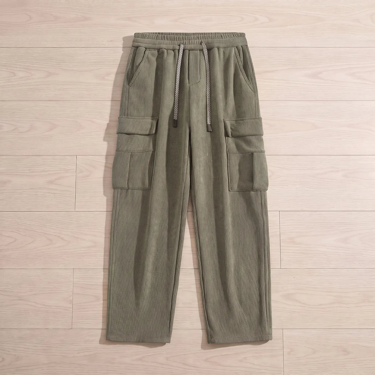 Fleece cord cargos in green corduroy laid flat on pale wooden floorboards