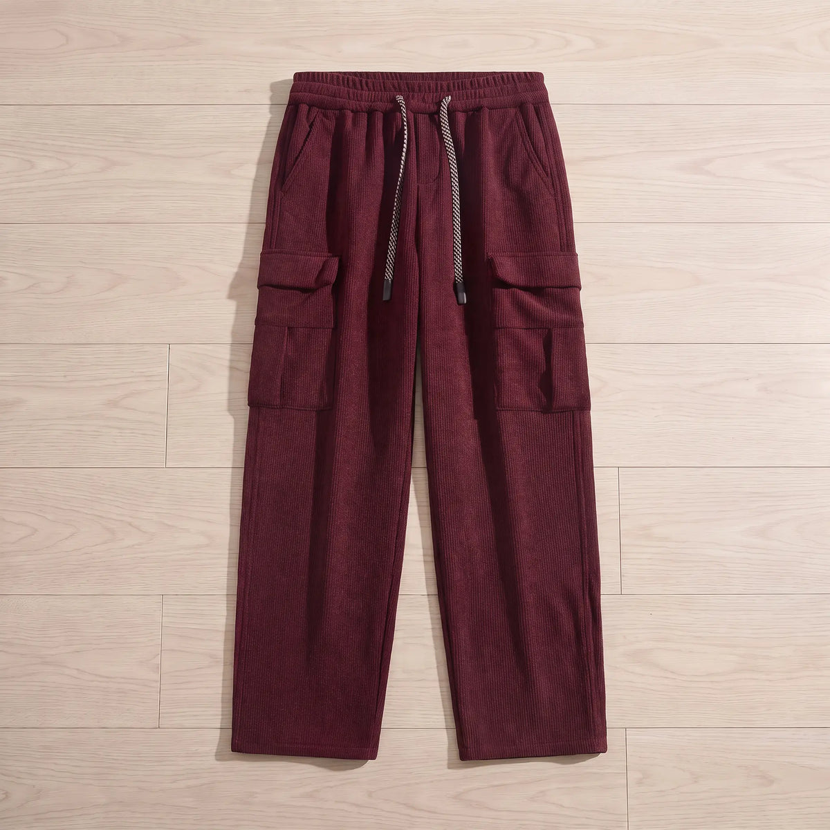 Fleece cord cargos in red corduroy laid flat on pale wooden floorboards