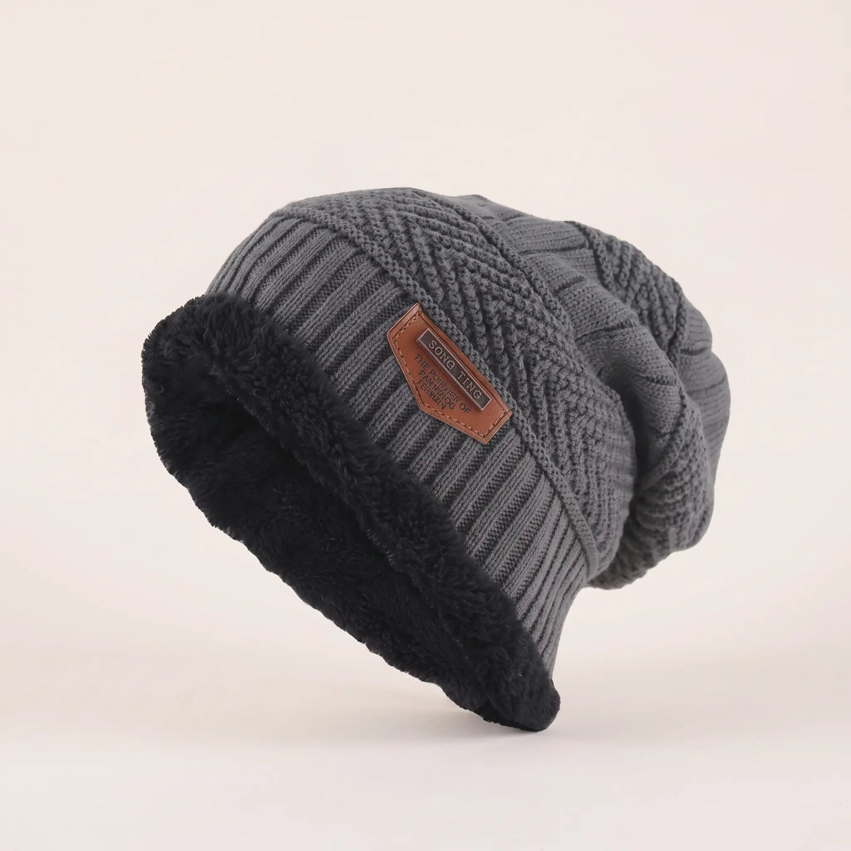Men's grey fleece-lined slouch beanie with textured knit, black fleece cuff and leather patch