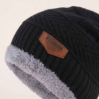 Close-up of black slouch beanie textured knit, leather patch and grey fleece cuff