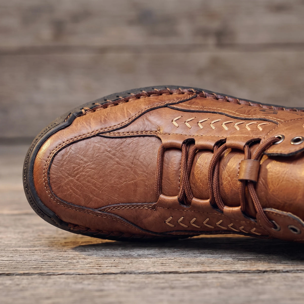 Close-up of the moc toe, contrast chevron stitching and lacing on the brown men's ankle boot