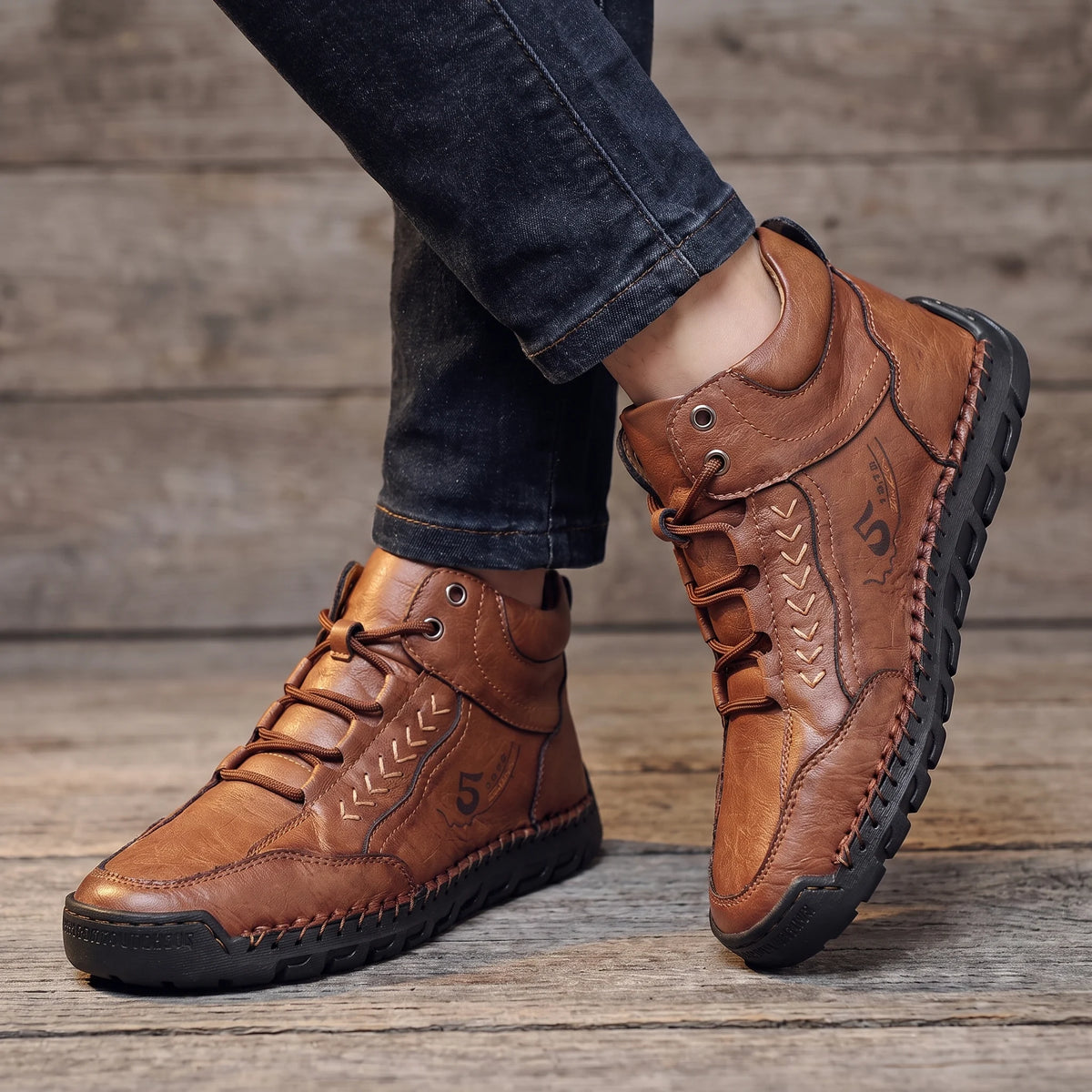 Man wearing the brown lace-up ankle boots with dark jeans, low close view of both boots