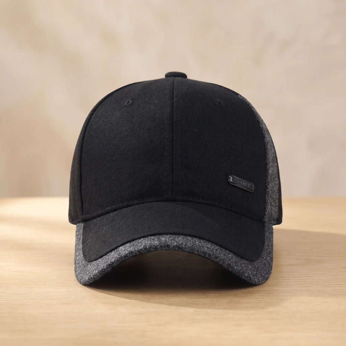Men's black winter baseball cap with grey heather side panel and brim edge, fold-down ear flaps tucked inside