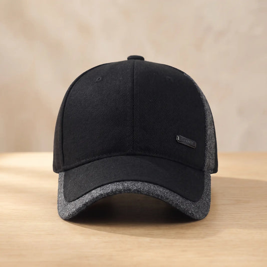 Men's black winter baseball cap with grey heather side panel and brim edge, fold-down ear flaps tucked inside